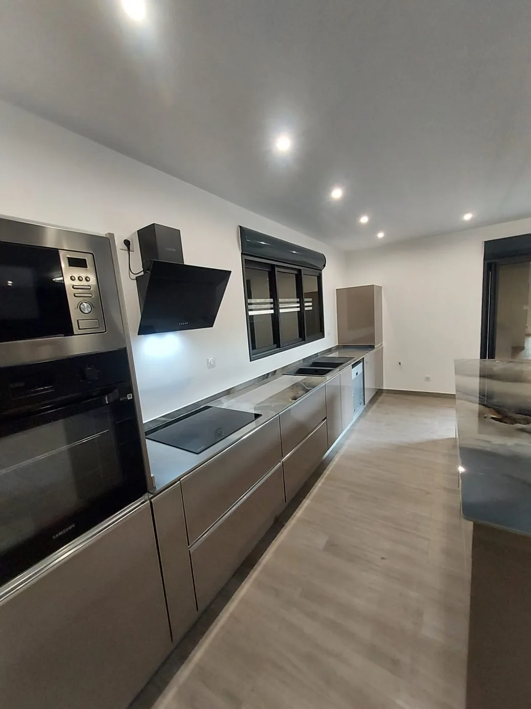 Cuisine taupe brillante en linéaire, four et plaque encastrés